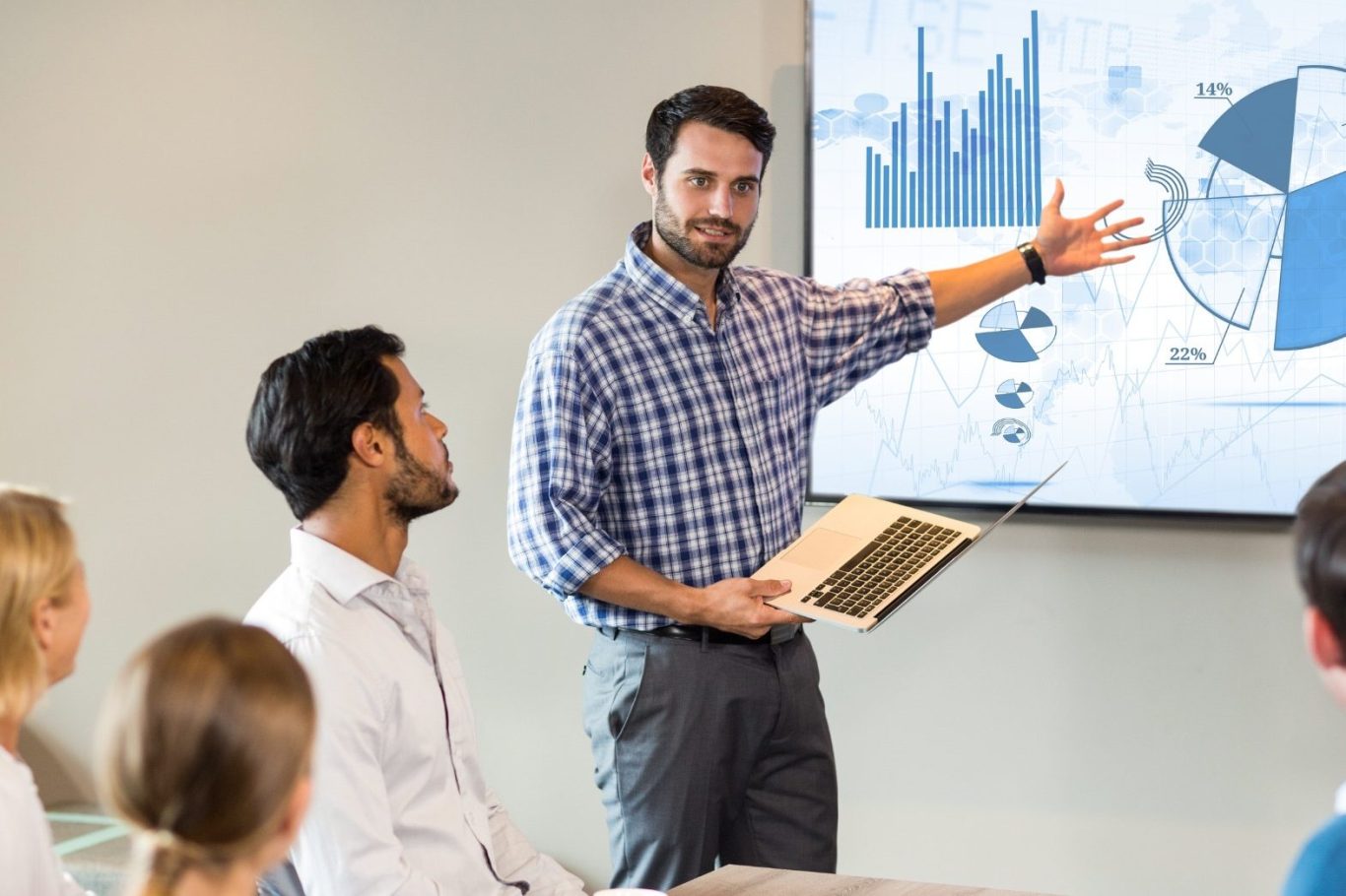 Ein Mann präsentiert Grafiken und Diagramme in einem Besprechungsraum.