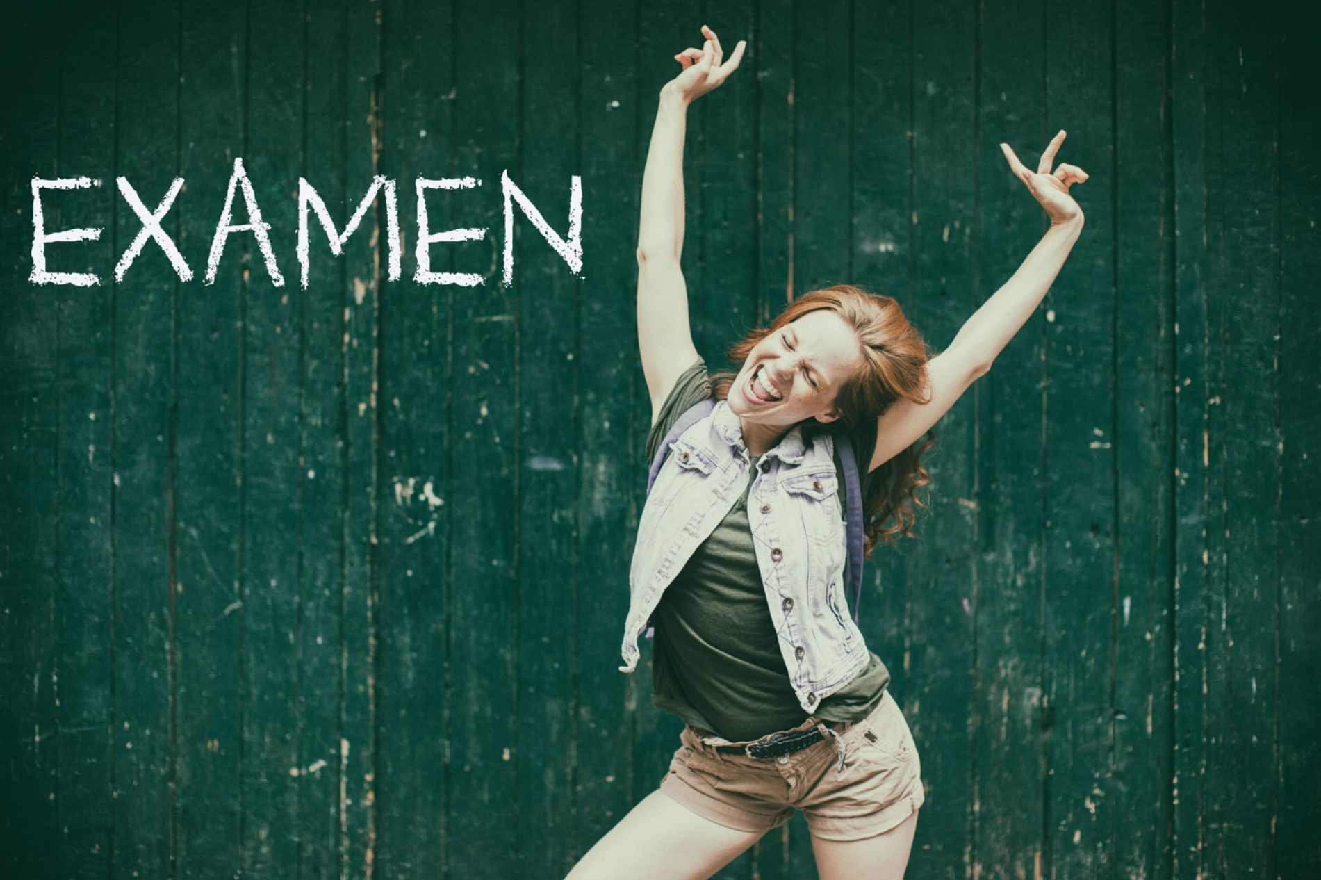 Junge Frau mit lockigen roten Haaren, freudig vor einer grünen Wand, armschwingend, Text: EXAMEN.